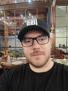 Helton Brito wearing a cap and glasses